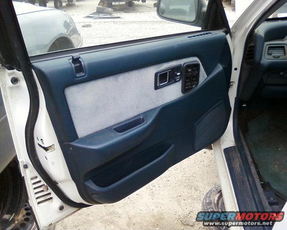 car door panel with power window controls and speaker grille