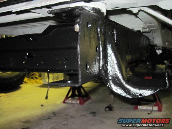 Close-up of black-painted vehicle frame and suspension parts on jack stands