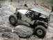1967 Ford Mustang - A custom-built off-road vehicle navigates a rocky trail, with onlookers observing the challenging terrain.