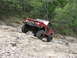 1967 Ford Mustang - A red Ford Bronco navigates a steep, rocky trail in a wooded area.