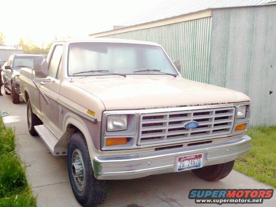 Tan 1980s Ford F-Series truck parked next to another vehicle, front view
