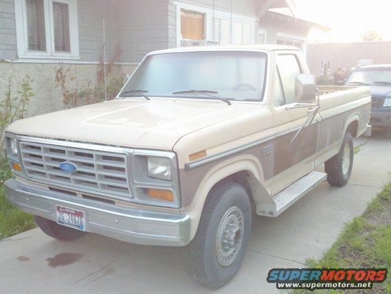 Tan and brown Ford pickup truck parked in driveway. Another SUV is visible behind it