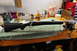 1991 Ford Bronco - Bolt-action rifle secured in a vise on a workbench, surrounded by various tools and cleaning supplies.