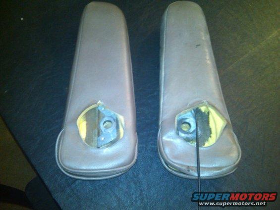 Two brown car armrests with mounting hardware visible