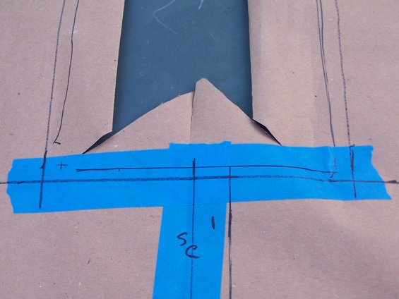 Diagram with blue tape and pencil markings, showing cut lines and measurements