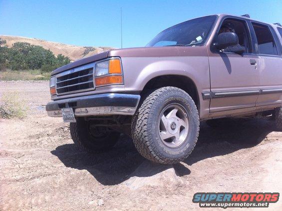 Brown Ford Explorer front 3/4 view on dirt terrain