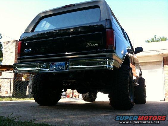 Rear view of a black 1996 Ford Bronco with oversized tires and a lifted suspension