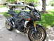 2008 Yamaha FZR1000 - A dark gray Yamaha FZR1000 motorcycle is parked on a concrete driveway with a green lawn and a pickup truck in the background.