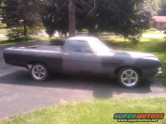Dark gray 1969 Ford Ranchero pickup truck, side view, with aftermarket wheels and a hood scoop