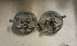 1991 Ford Festiva - These are two brake backing plates, likely for a drum brake system, resting on a concrete surface.
