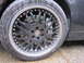 1972 Ford Bronco - Close-up of a custom black alloy wheel with a chrome lip, showing water droplets on the tire and wheel.