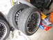 1972 Ford Bronco - Aftermarket wheels and tires are stored on a concrete floor next to a pair of work gloves.