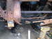 1973 Ford Ranchero - Close-up view of the undercarriage of a vehicle, showing rusted metal and various mechanical components.