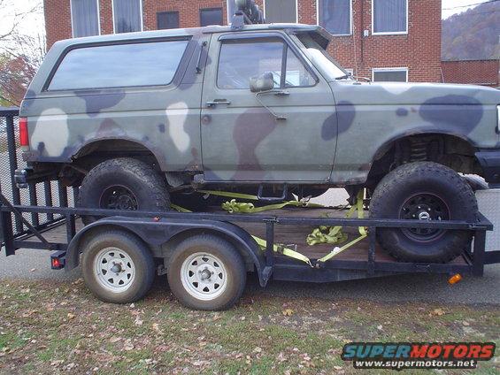 Camouflaged 1990 Ford Bronco side view on a trailer