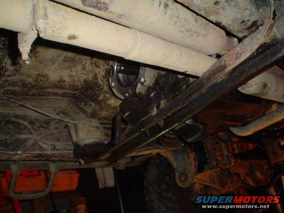 Underside view of a vehicle's drivetrain components, including exhaust pipes and suspension parts