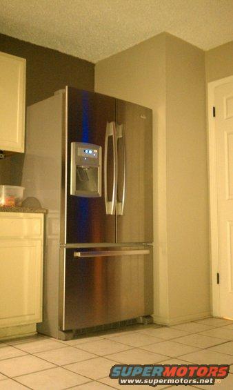 Stainless steel refrigerator with ice and water dispenser, located in a kitchen