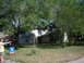 1983 Ford 427 - A man gestures towards a residential property with a "For Sale" sign prominently displayed on the lawn.
