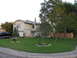 1983 Ford 427 - A black pickup truck is parked in the driveway of a two-story house with a well-maintained lawn.