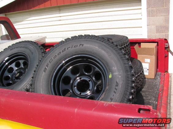 Spare BFGoodrich All-Terrain tires on black rims in red truck bed