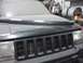 2001 Volkswagen Jetta - The grille and headlight of a dusty Jeep Grand Cherokee are visible from the front.