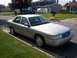 2004 Mercury Grand Marquis - A silver sedan is parked curbside on a sunny day in a suburban neighborhood.