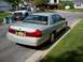 2004 Mercury Grand Marquis - Silver 2004 Mercury Grand Marquis seen from the rear, parked on a residential street with a utility truck in the background.