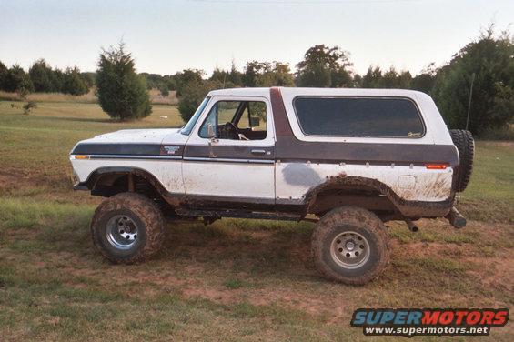 1978 Ford Bronco lifted with large tires, parked in a grassy field