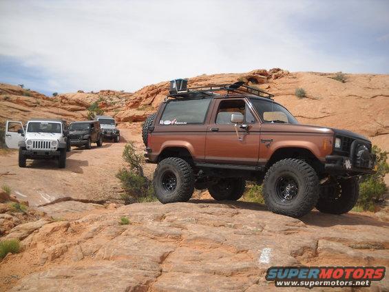 1986 Ford Bronco II and three Jeeps on a desert trail