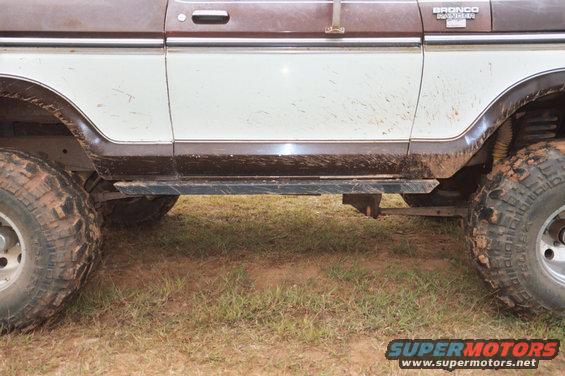 1978 Ford Bronco side view, brown and white paint, mud splatters, rock skids, off-road tires