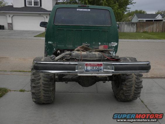 1989 Ford Bronco rear view, modified with large tires and lifted suspension. Some engine components visible