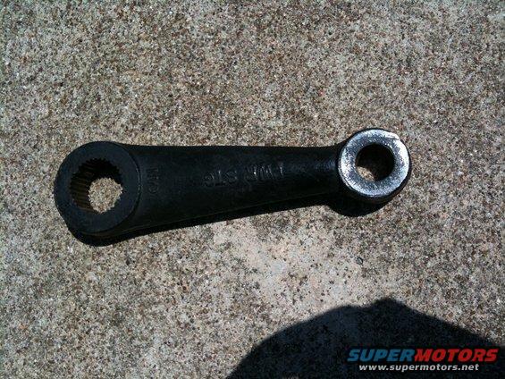 Black metal steering linkage arm with splined hole on one end and round hole on the other. Text reads 'TWR STG'