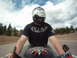 2006 Honda CBR-RR - A rider on a motorcycle travels down a highway under a cloudy sky, with trees lining the road.