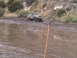 1986 Ford Bronco - This lifted Ford Bronco is tackling a challenging muddy terrain, showing its off-road capabilities.