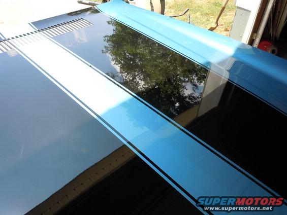 Black hood with blue and white racing stripes, showing louvers