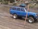 1986 Ford Bronco - Multiple off-road vehicles navigate a muddy trail during an outing.