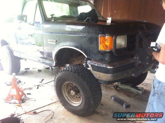 Black Ford Bronco with lifted suspension and large tires, front end visible, undergoing modifications