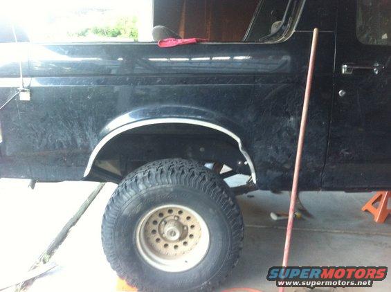 Black 1990 Ford Bronco side view, lifted with large tires