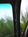 2002 Toyota 4Runner - View from inside a vehicle shows an interior pillar and an antenna against a green, treed background.