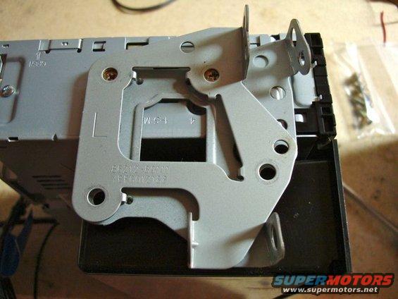 Car stereo mounting bracket with part numbers visible