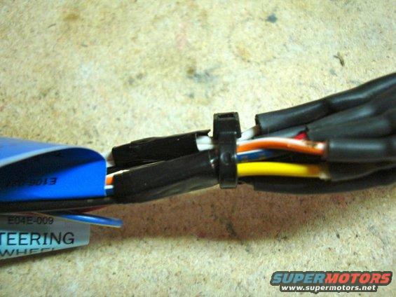 Close-up of a wiring harness with a blue label that says STEERING WHEEL