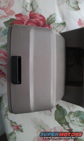 Tan plastic center console armrest lid with black latch