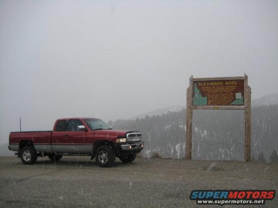 1997 Dodge 2500 pickup truck parked on gravel with a historical marker and snowy mountains in background