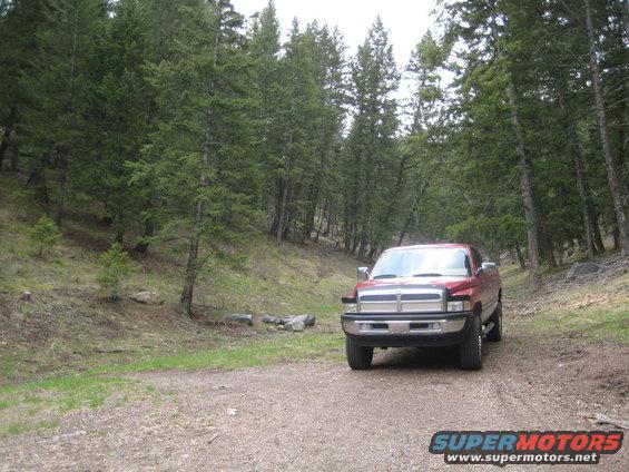 red 1997 Dodge 2500 parked on a dirt road in a forest