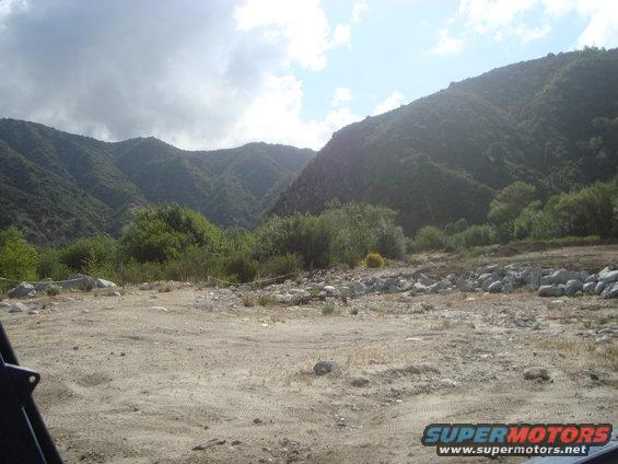 Dirt road in a mountainous area with trees and rocks