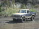 1986 Ford Bronco - This Ford Bronco is navigating a wet, muddy off-road path.