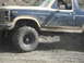 1986 Ford Bronco - This 1986 Ford Bronco is shown in a 3/4 front view, navigating through muddy terrain.