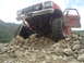 1986 Ford Bronco - This red off-road truck appears to be from the 1970s, not 1986, and is struggling on a rocky incline.