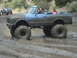 1986 Ford Bronco - A heavily modified Chevrolet K5 Blazer navigates a muddy terrain with its occupants.