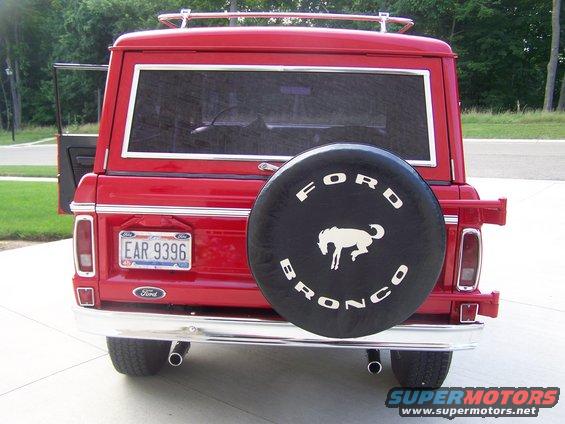 Red 1975 Ford Bronco rear view with spare tire cover and license plate EAR 9396