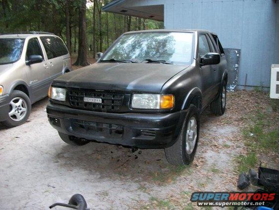 Black Isuzu Trooper parked next to a silver minivan